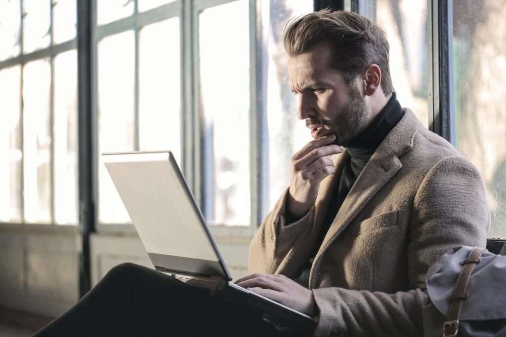 Man looking at screen questioning something