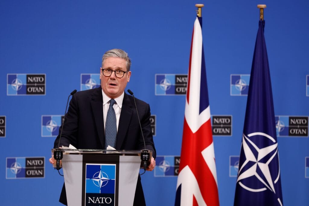 Keir Starmer standing in front of UK and EU flag